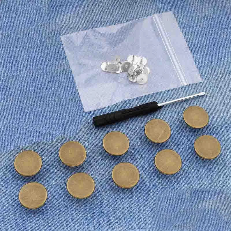 Silver metal button pins are displayed on a white plastic sheet against a blue fabric background.