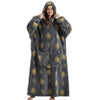 A woman wearing a gray sherpa fleece oversized blanket hoodie with gold lion patterns.