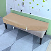 A beige stretch pu leather waterproof bench slipcover placed on a light gray tiled floor.