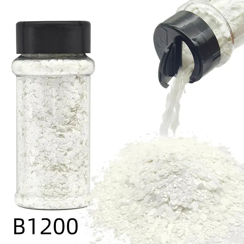 A glass bottle labeled B1200 containing white glitter mix with a black cap and a pile of the same material.