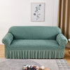 A teal stretch knit sofa cover featuring a bubble lattice texture displayed in a living room setting.