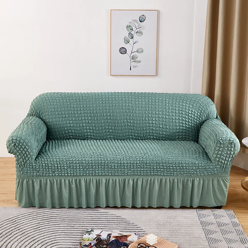 A teal stretch knit sofa cover featuring a bubble lattice texture displayed in a living room setting.