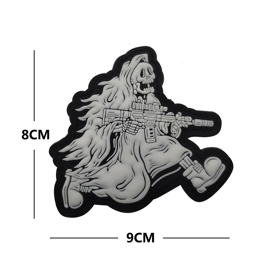 A black silhouette of a skull with flowing hair and a rifle, designed as a glow-in-the-dark biker patch.