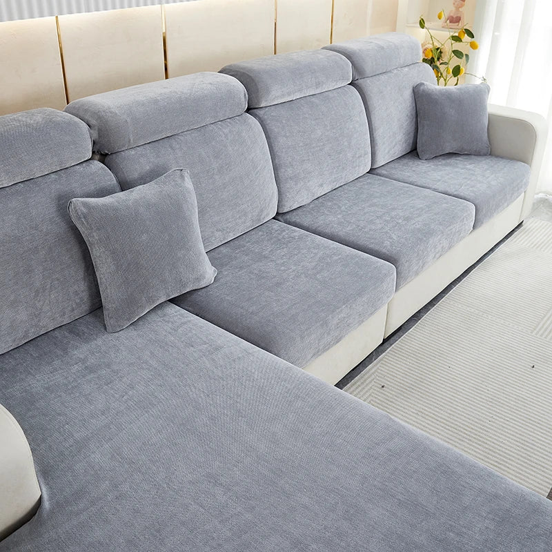 A light gray stretchable chenille sofa cushion cover with matching throw pillows on a modern sofa.