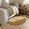 A natural jute non-slip entrance door mat placed on a light wood floor next to a bed.