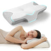 A white contoured memory foam sleep pillow is shown next to a woman sleeping on a bed.