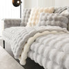 A fluffy gray and cream textured duvet cover with quilted details displayed on a bed.