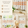 White lace cafe curtain with orange floral embroidery and butterfly applique softening light in a kitchen window.