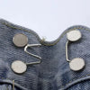 Silver metal button snaps attached to denim fabric