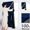 A woman is installing blackout curtains on a window, showing the fabric and installation process.