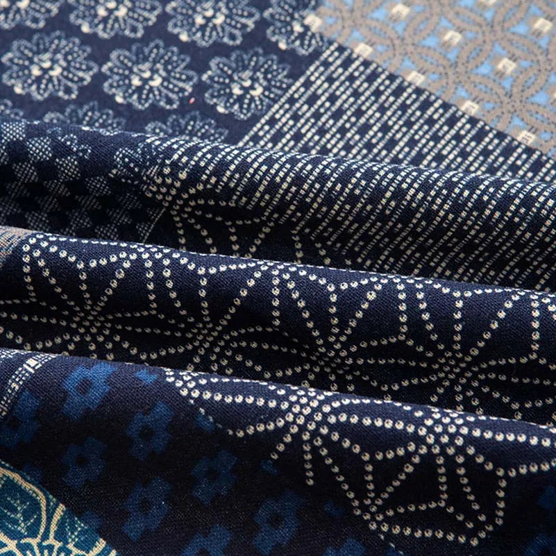 Close-up of dark blue and white patterned linen fabric folds showing intricate geometric designs