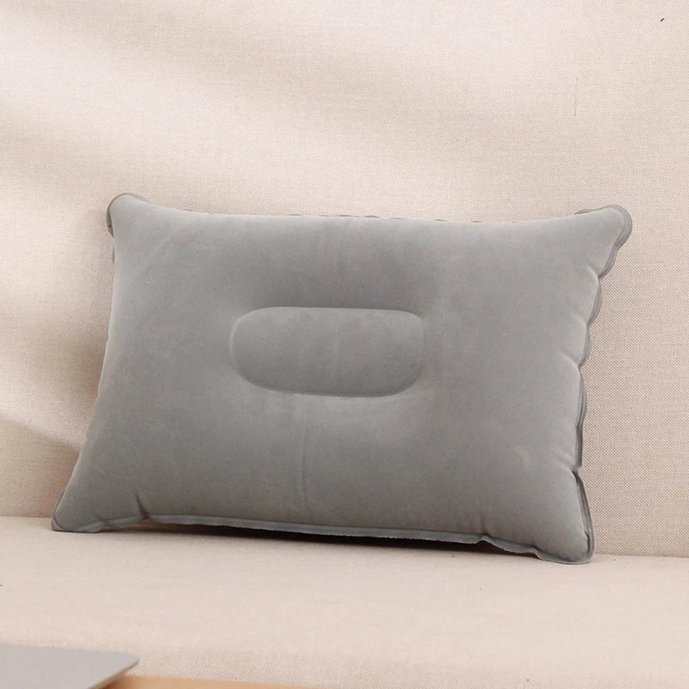 A gray inflatable travel neck pillow resting on a light-colored surface.