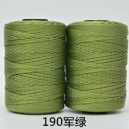 Two spools of light green yarn or cord used for hand knitting and crochet crafting