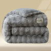 A thick, gray plush rabbit quilt comforter folded and displayed on a light surface.