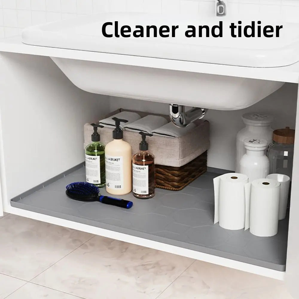 A white under sink cabinet liner mat with various cleaning products and toiletries visible.