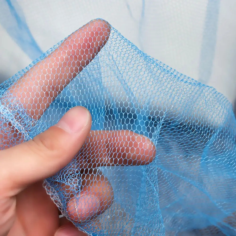 A hand holds a light blue lace dome mosquito net canopy, showing its mesh texture.