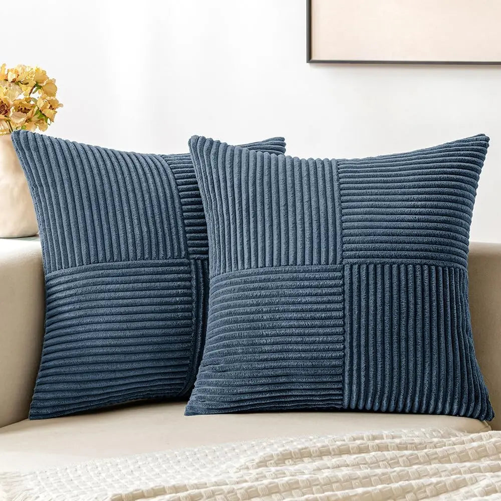 A set of four navy blue corduroy throw pillow covers with a vertical ribbed texture and a patchwork design.