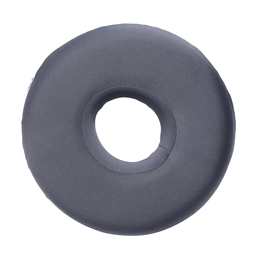 A round, gray ear piercing pillow designed for comfort during sleep.