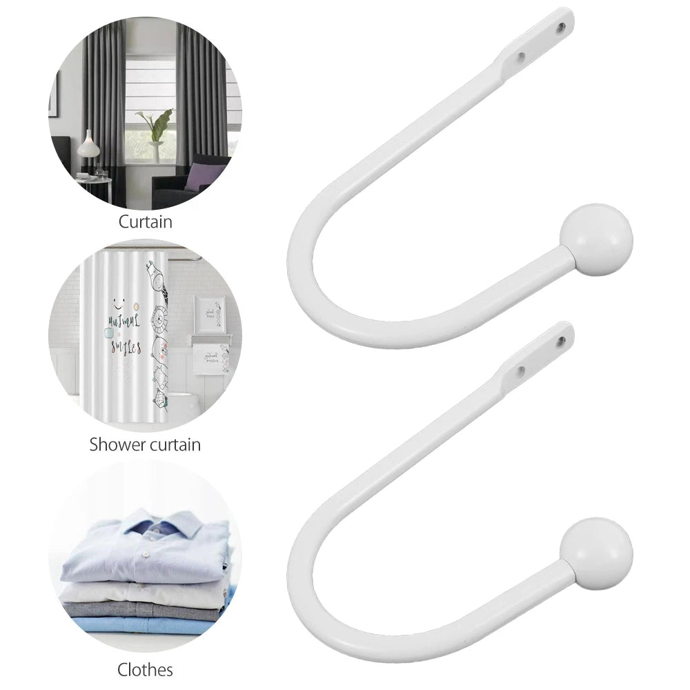 A set of white retro metal curtain holdback hooks used for hanging curtains and shower curtains.