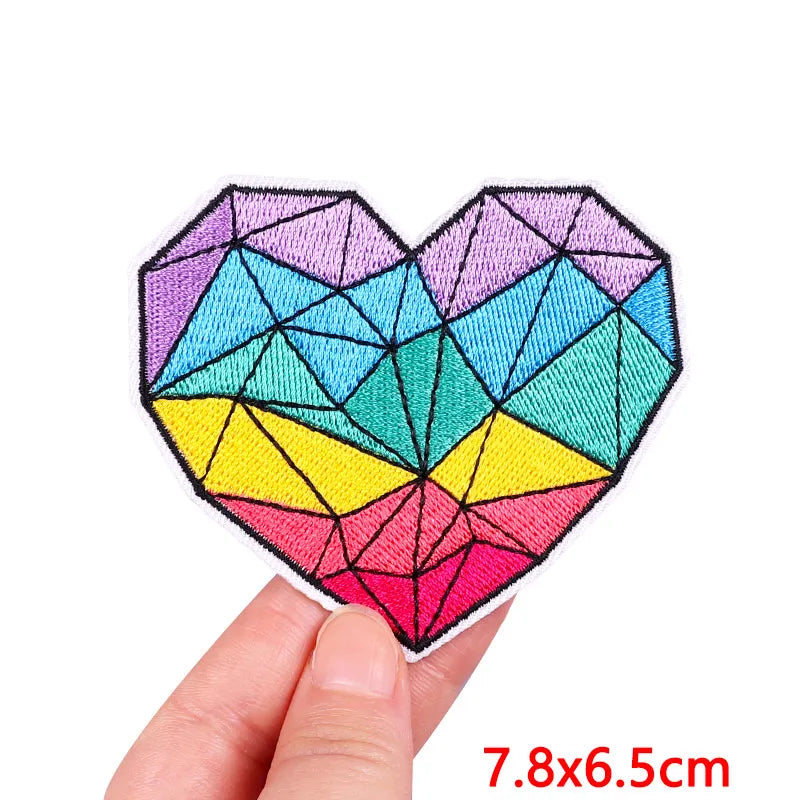 A colorful, geometric heart shape made of embroidered patches for clothing.