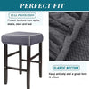 A dark gray jacquard elastic bar stool slipcover with a textured fabric and a padded seat.