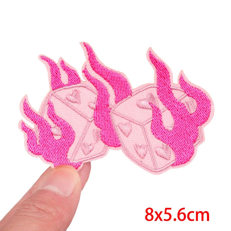 Pink rose skull embroidery patch for clothing shown being held by a hand