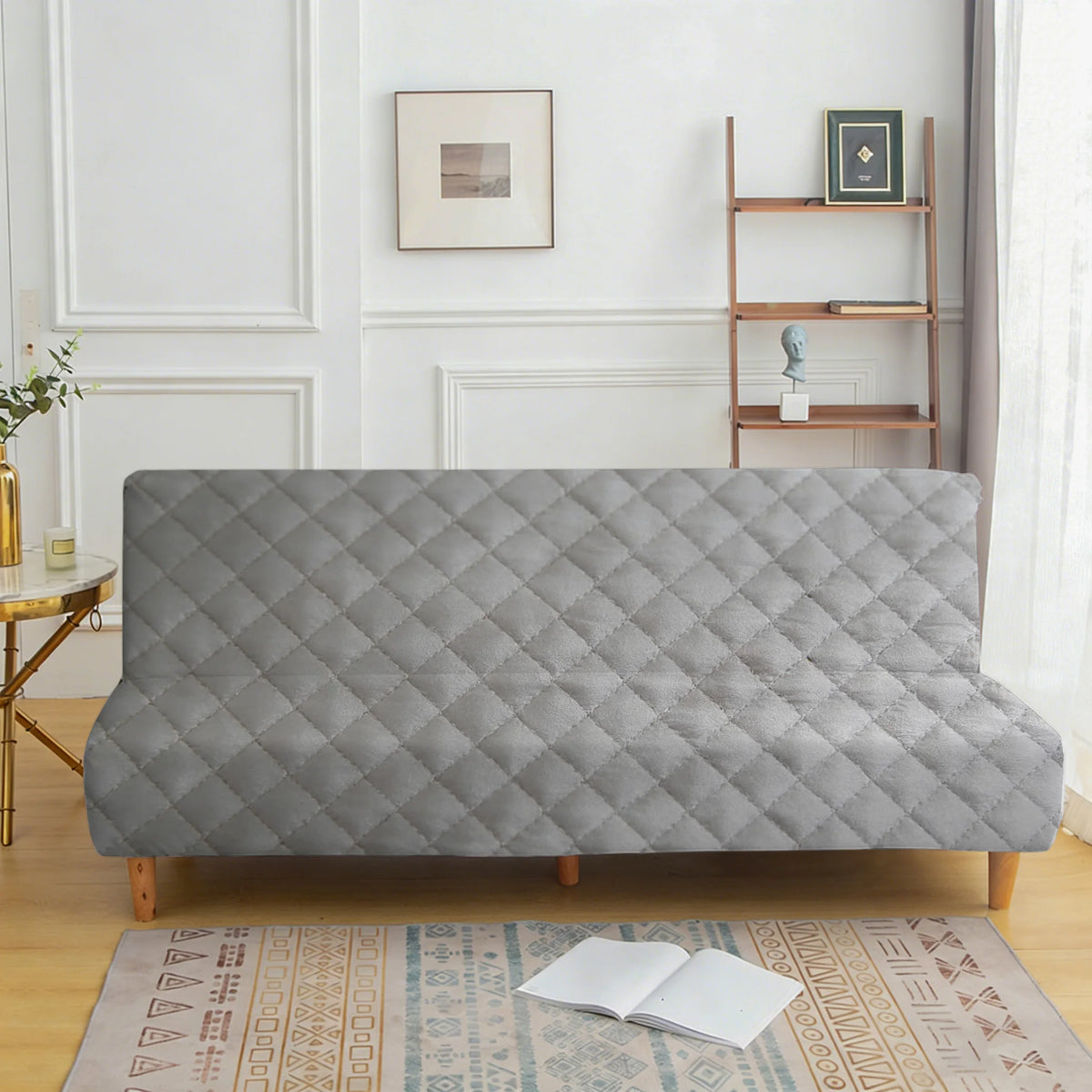 A gray velvet non-slip armless sofa cover displayed on a wooden floor with a patterned rug.