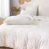 White bohemian grid tufted duvet cover set on a bed with natural light and woven accents