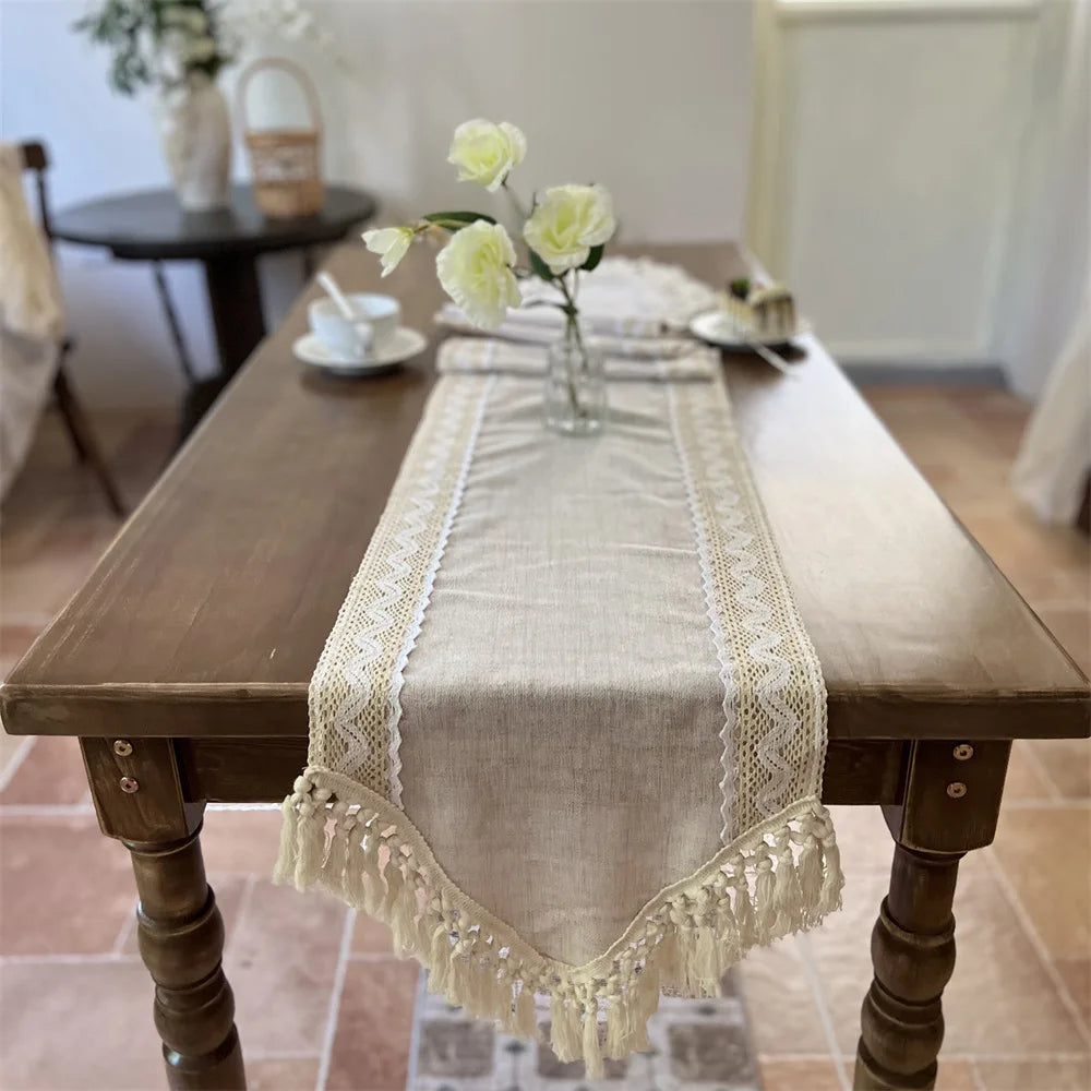 A beige crochet macrame lace table runner displayed on a wooden table.