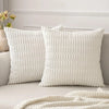 A white textured corduroy throw pillow cover displayed on a sofa with a white headboard and a cream blanket.