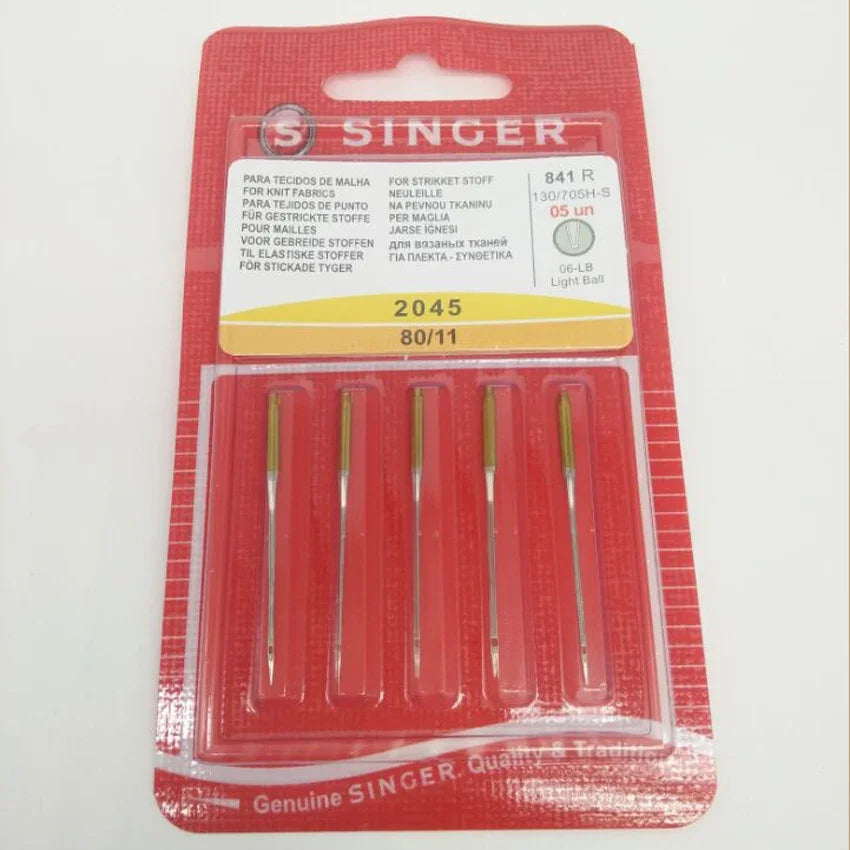 A package of Singer sewing needles in a red plastic case with yellow labeling and a red background.
