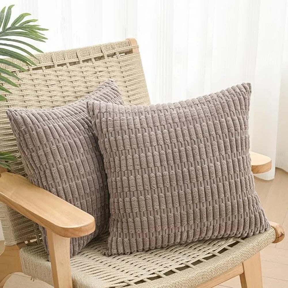 Two gray knitted throw pillow covers resting on a woven outdoor chair.