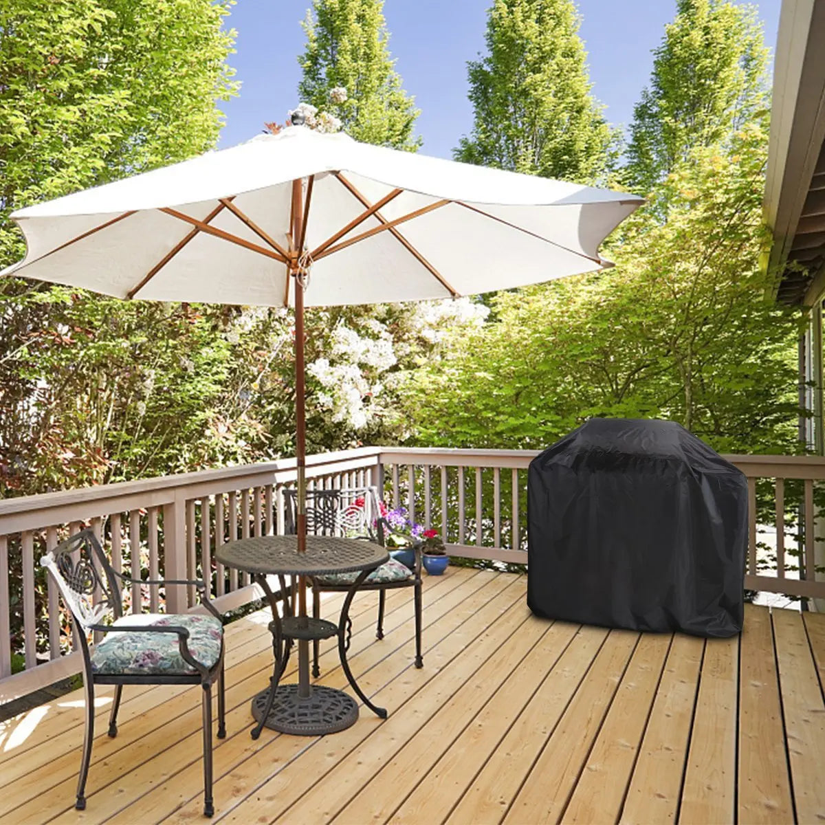 A heavy-duty outdoor BBQ grill cover is displayed on a wooden deck under a large white umbrella.