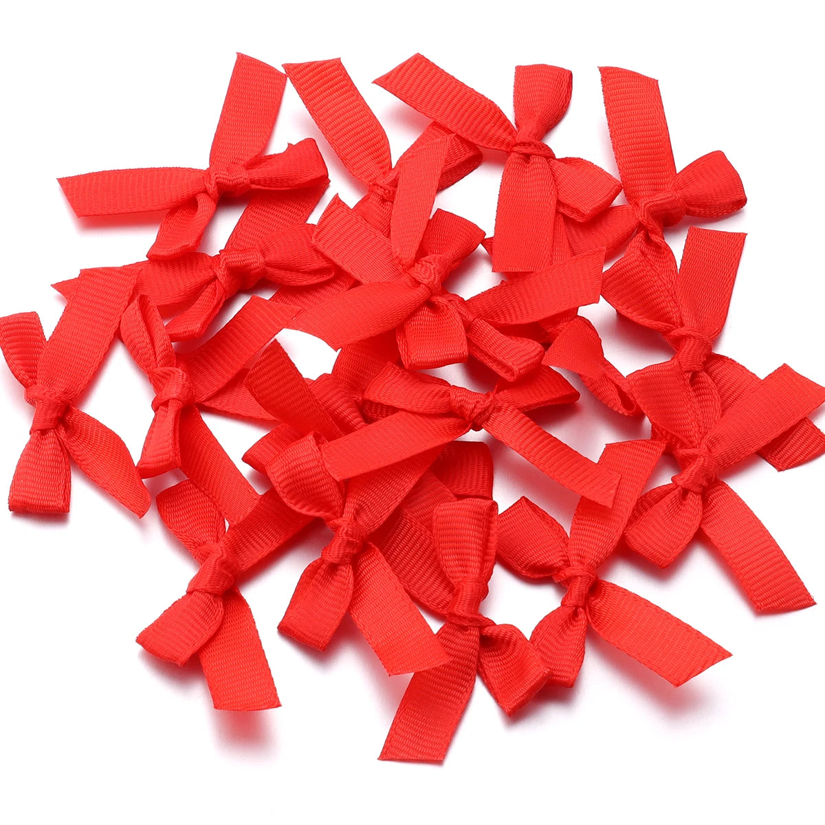 A pile of bright red satin ribbon bows for craft and decoration.