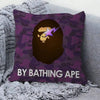 A purple camouflage pillow cover featuring a stylized golden face with a purple lightning bolt and the text BY BATHING APE