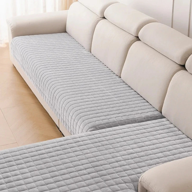 A light beige L-shaped corner sofa covered in gray quilted flannel fabric.
