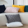 A set of two ultra-soft velvet decorative pillow covers in shades of navy, pink, yellow, and gray displayed on a sofa.