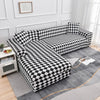 A black and white checkered printed sofa protector cover displayed on a gray rug.