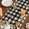 Autumn plaid table runner featuring a pumpkin dwarf design with fall leaves and candles.