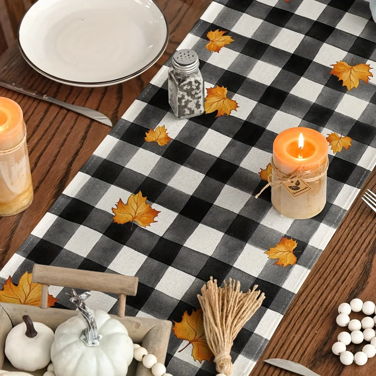 Autumn plaid table runner featuring a pumpkin dwarf design with fall leaves and candles.