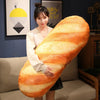 A woman holds a large, elongated French bread plush pillow with striped orange and yellow coloring.