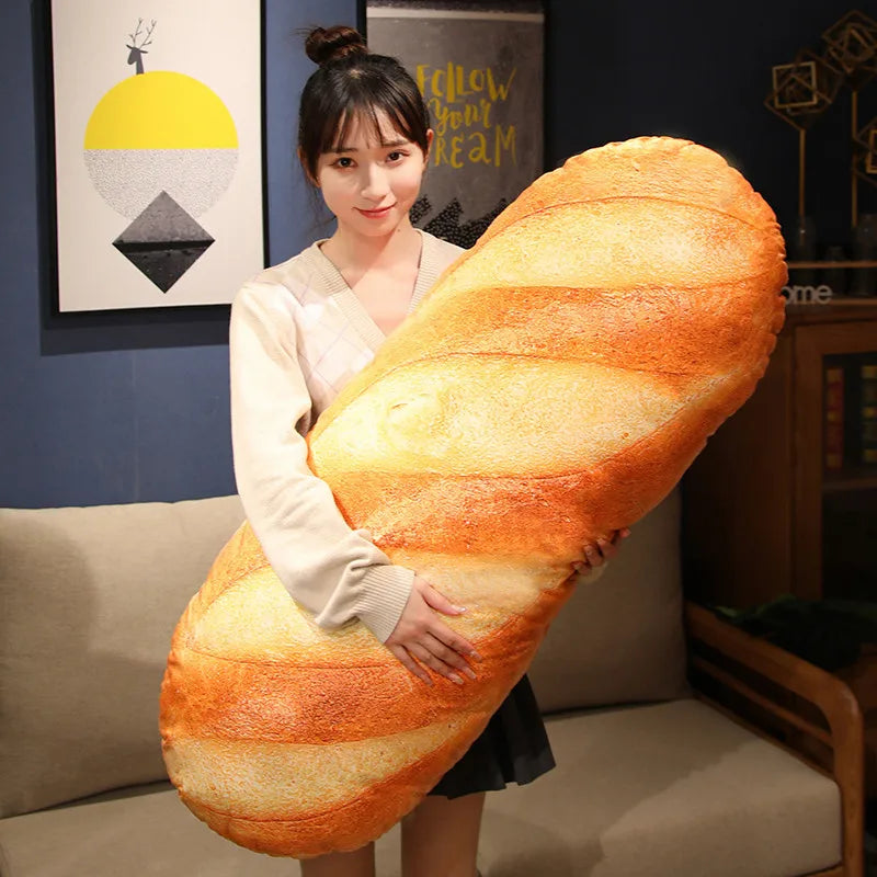 A woman holds a large, elongated French bread plush pillow with striped orange and yellow coloring.