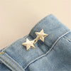 Silver star-shaped button clips attached to a blue denim fabric