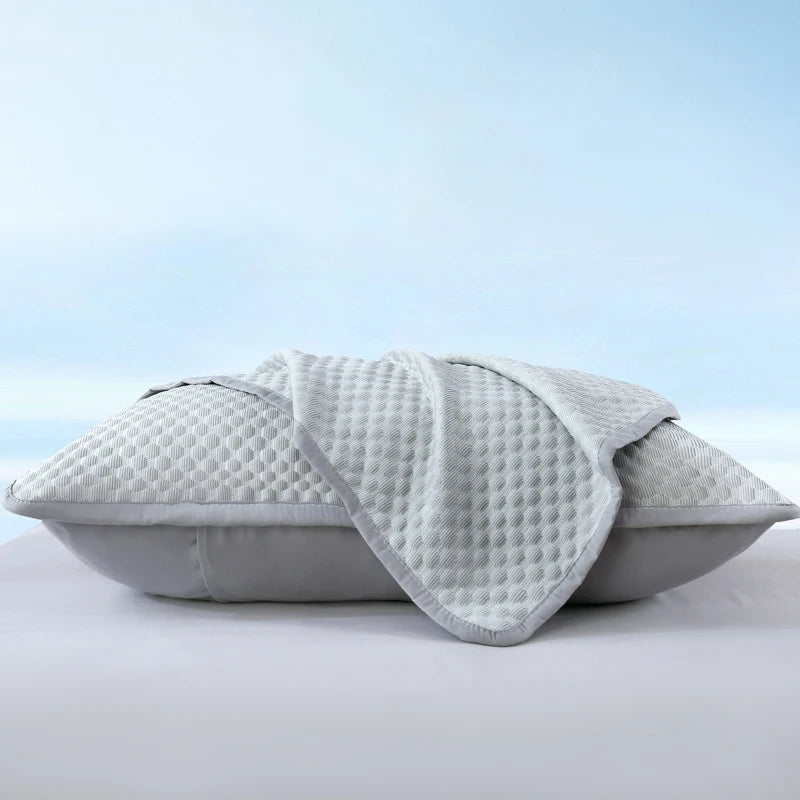 A light gray summer cooling bean pillow cover folded and displayed on a white surface.