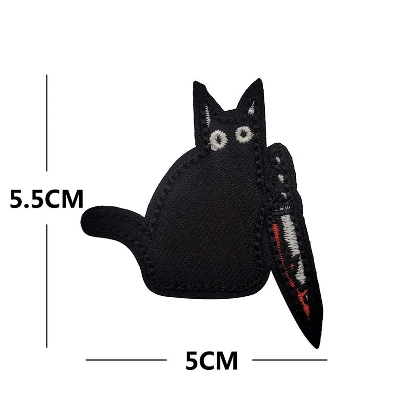 A black cat embroidery patch with white eyes and a textured edge.