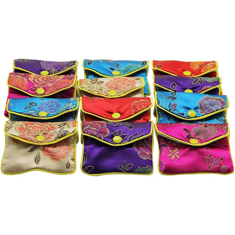 A collection of multi-color silk brocade jewelry pouches in various floral patterns and vibrant colors.