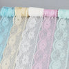 Rolls of decorative lace ribbon in various pastel colors including light blue, cream, white, pink, and mint green.