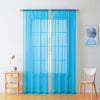 A pair of light blue sheer voile curtains hanging in a window frame against a white wall.