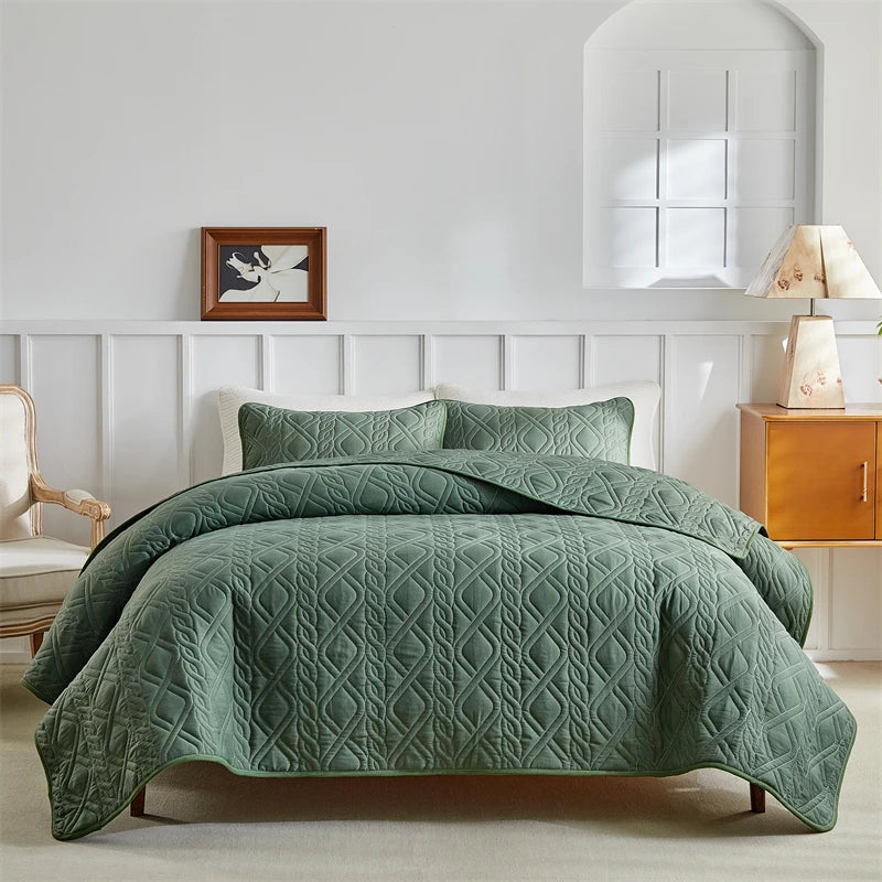 A light green quilted duvet and bedding set on a bed with white paneled headboard.