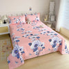 Pink flat bed sheets with blue and white floral print on a double bed